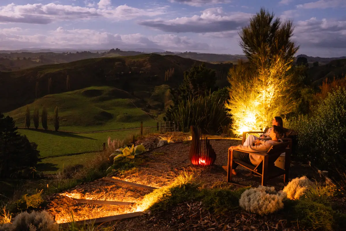 Couple by firepit at night, secluded couples accommodation Waitomo New Zealand