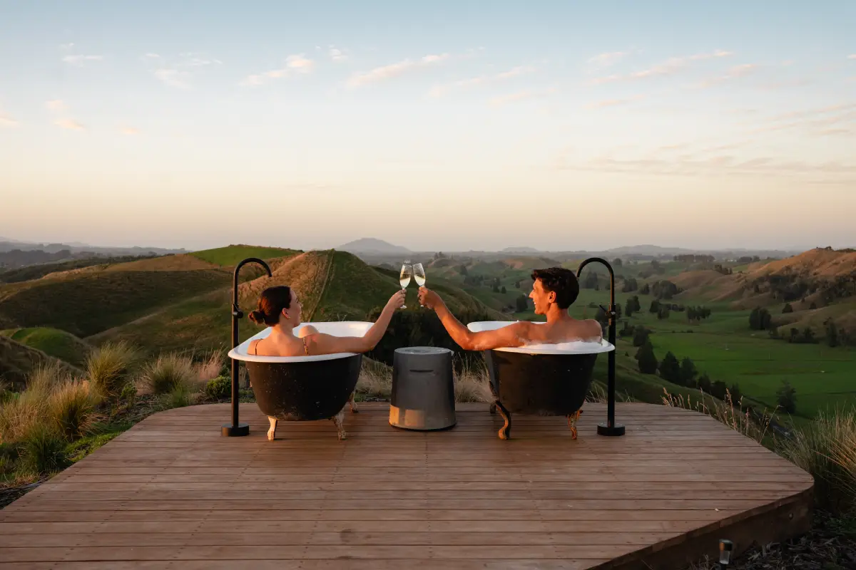 Twin outdoor baths at sunset, Kōwhai Tent couples accommodation Waitomo
