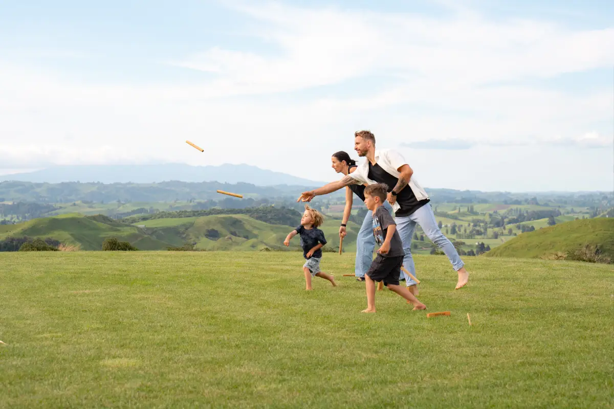 Family playing lawn games at Pōhutukawa Tent, glamping Waitomo