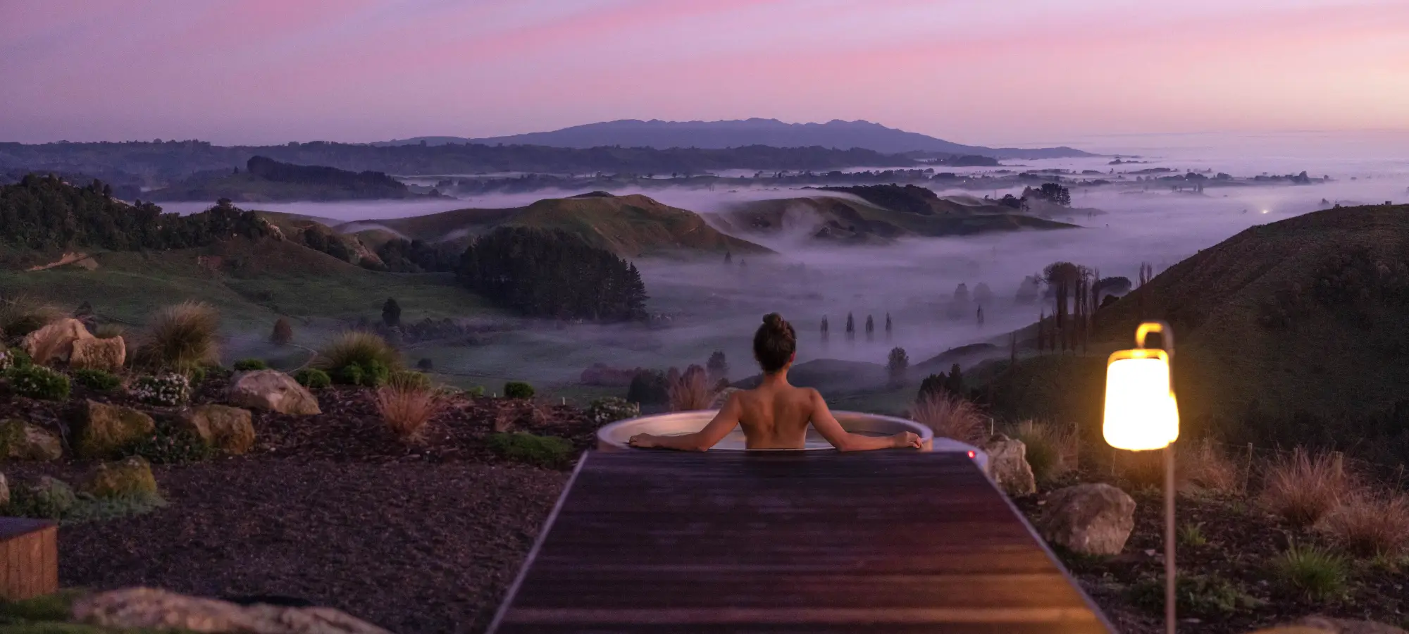 Pōhutukawa Tent cedar hot tub above the morning mist at sunrise, Waitomo New Zealand