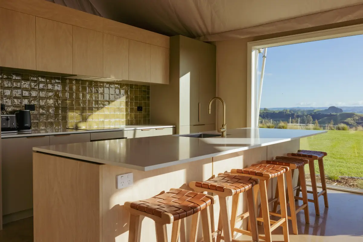 Pōhutukawa Tent lounge with indoor fireplace and panoramic windows, Waitomo
