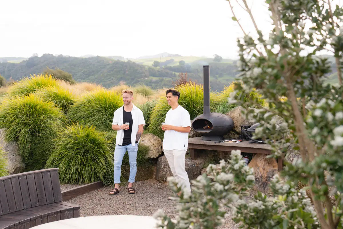 Pōhutukawa Tent queen bedroom with warm lighting, luxury glamping Waitomo